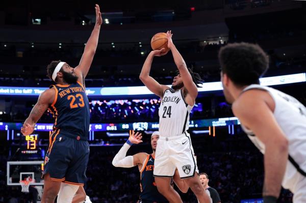 Nets guard Cam Thomas puts up a shot as Knicks center Mitchell Robinson.