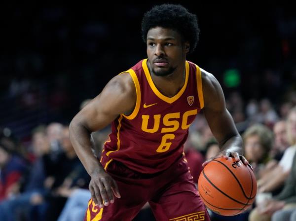 Bro<em></em>nny James, in his USC basketball uniform, dribbling the ball during a game against UCLA