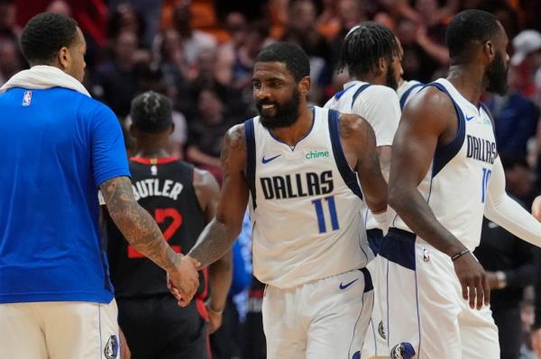 Kyrie Irving celebrates with a teammate during the Mavericks' 111-92 win over the Heat.