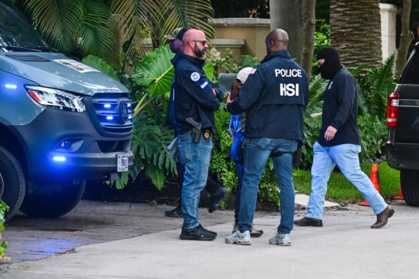 Federal and Homeland Security Investigation agents are seen at the entrance of Sean "Diddy" Combs's home at Star Island in Miami Beach on March 25, 2024.