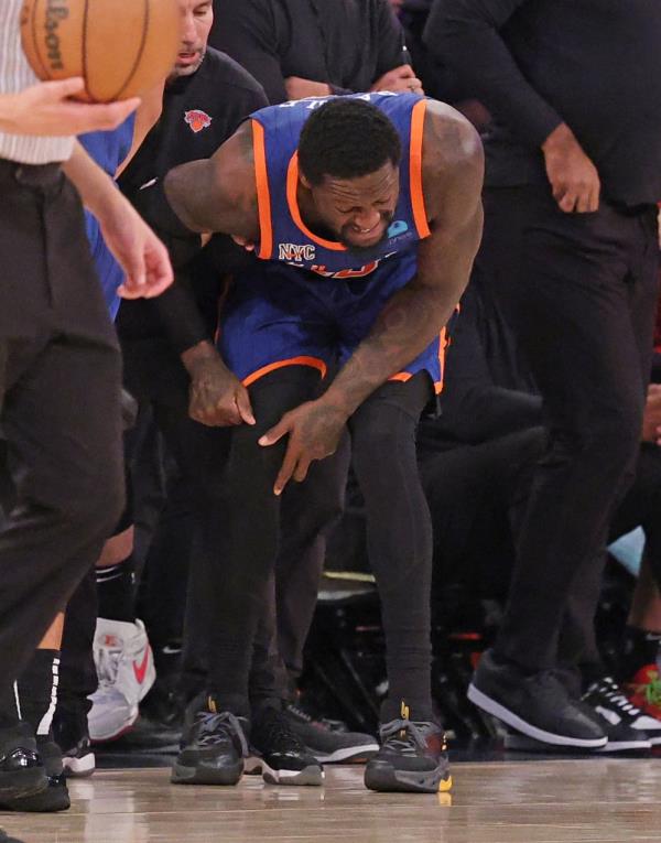 Julius Randle of the New York Knicks being assisted by a trainer after falling and injuring his arm in a game against the Miami Heat