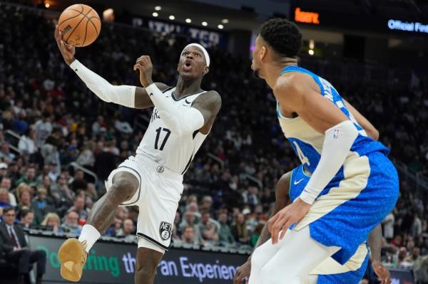 Dennis Schroder, who scored five points and had nine assists, goes up for a layup as Giannis Antetokounmpo looks on during the Nets' loss. 