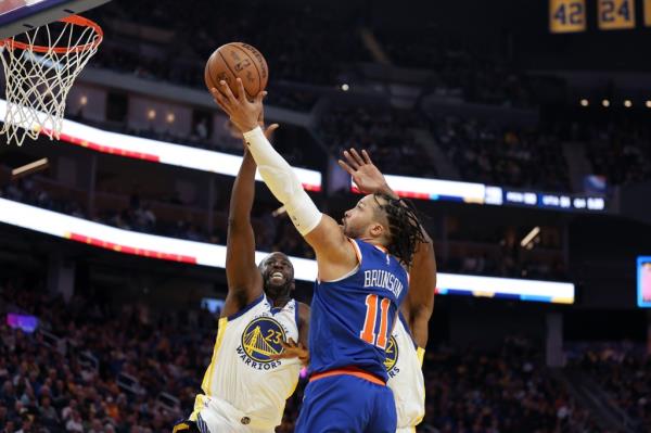 Jalen Brunson drives to the basket against Draymond Green on Mo<em></em>nday night.