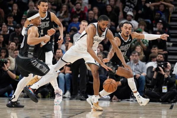 Anto<em></em>nio Spurs forward Keldon Johnson (3) and guard Tre Jo<em></em>nes (33) battle for the loose ball with Brooklyn Nets forward Mikal Bridges (1) during overtime at Moody Center.