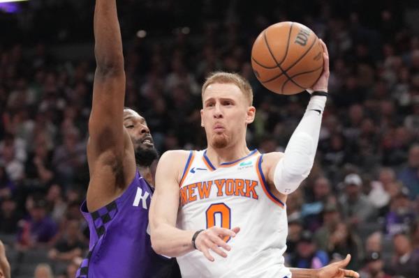 Do<em></em>nte DiVincenzo passes basketball while Harrison Barnes defends during an NBA game between New York Knicks and Sacramento Kings.