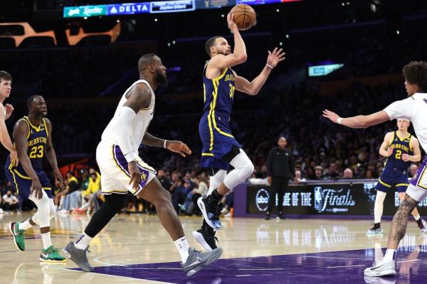 Stephen Curry #30 of the Golden State Warriors shoots past the defense of LeBron James #23 of the Los Angeles Lakers during the second half.