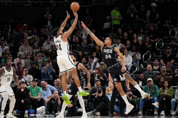 Nets guard Cameron Thomas (24) shoots over San Anto<em></em>nio Spurs guard Devin Vassell (24) during the first half at Moody Center.