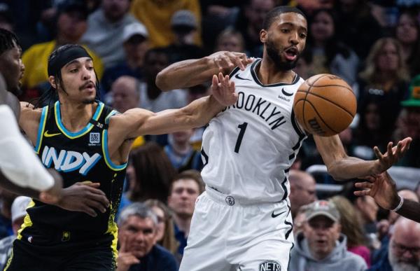 Mikal Bridges (right) and Andrew Nembhard battle for a loose ball during the Nets' 121-100 loss to the Pacers.