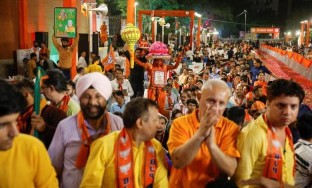 A large crowd of people, many wearing orange or yellow.