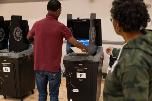 People scan ballots at a polling station during a primary election at Co-op City in the Bronx, borough of New York, on June 25, 2023. 