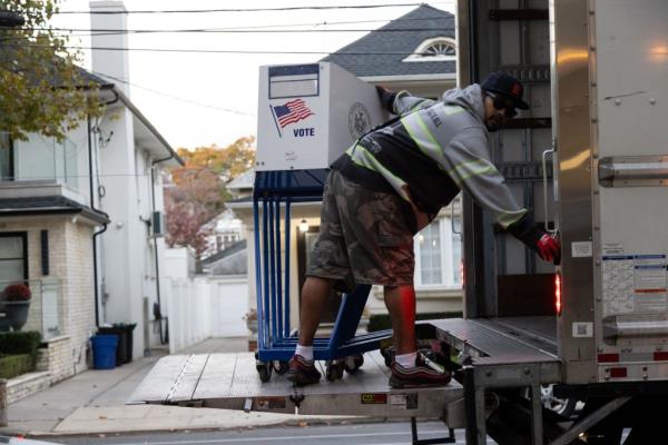 A worker delivers voting privacy booths ahead of the upcoming presidential election at James Madison High School on Tuesday, October 22, 2024 in Brooklyn, NY. 